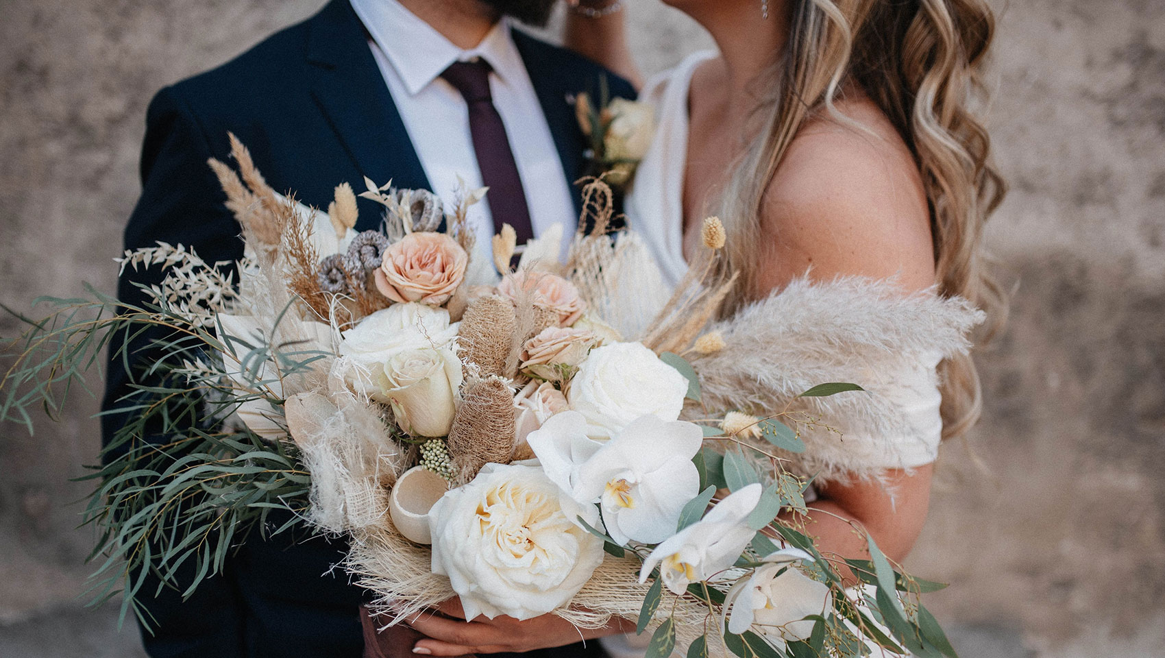 bride and groom next to each other holding a bouquet