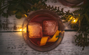 Holiday Cocktail with ice cubes and orange rind