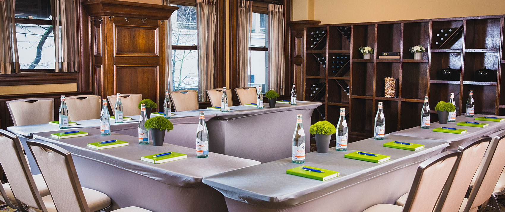 U-Shape meeting room set up with bottles of wine on the wall